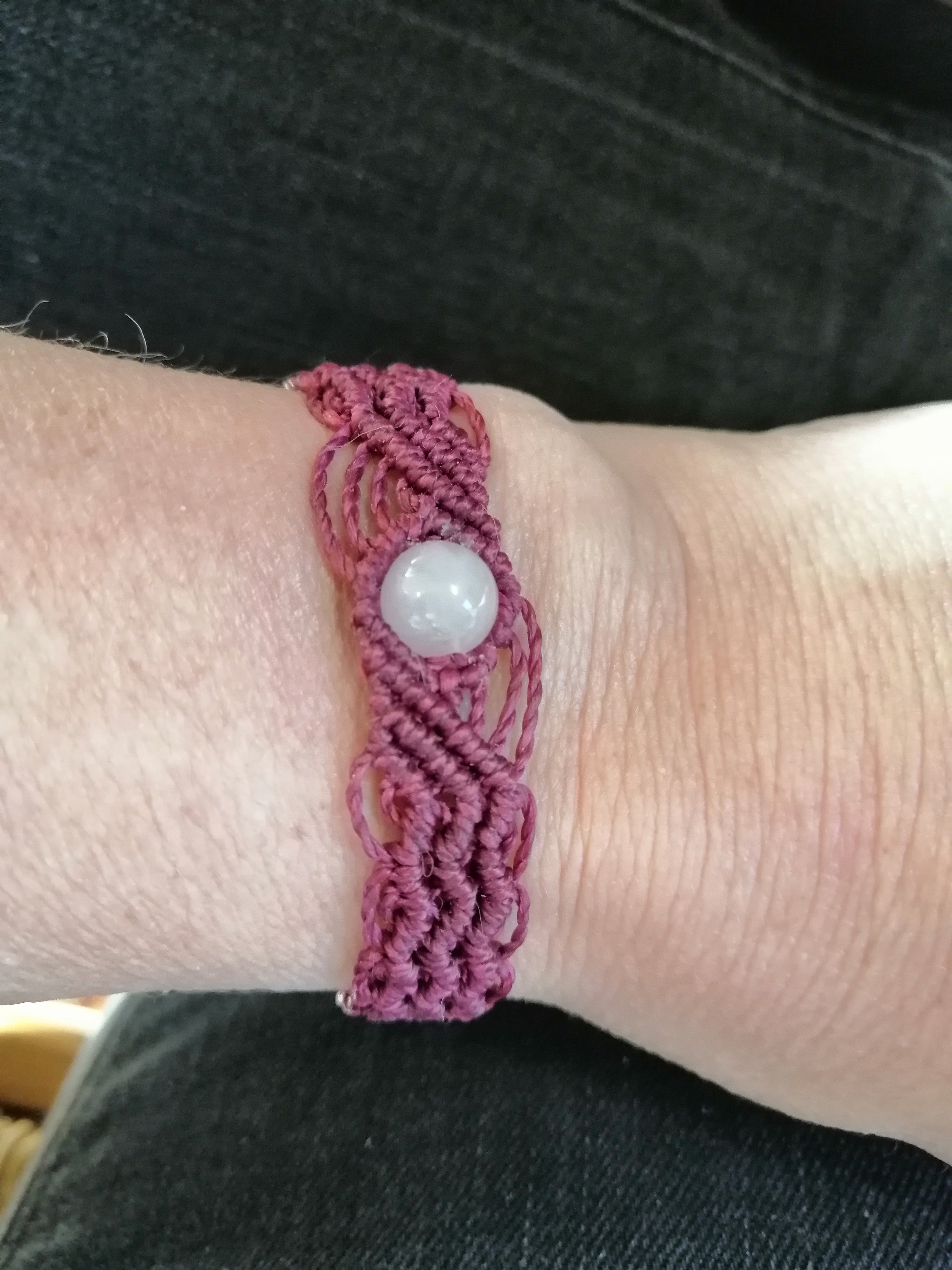 bracelet modèle @solyluna tissé a la main en micro macramé de couleur prune avec une perle en quartz rose.