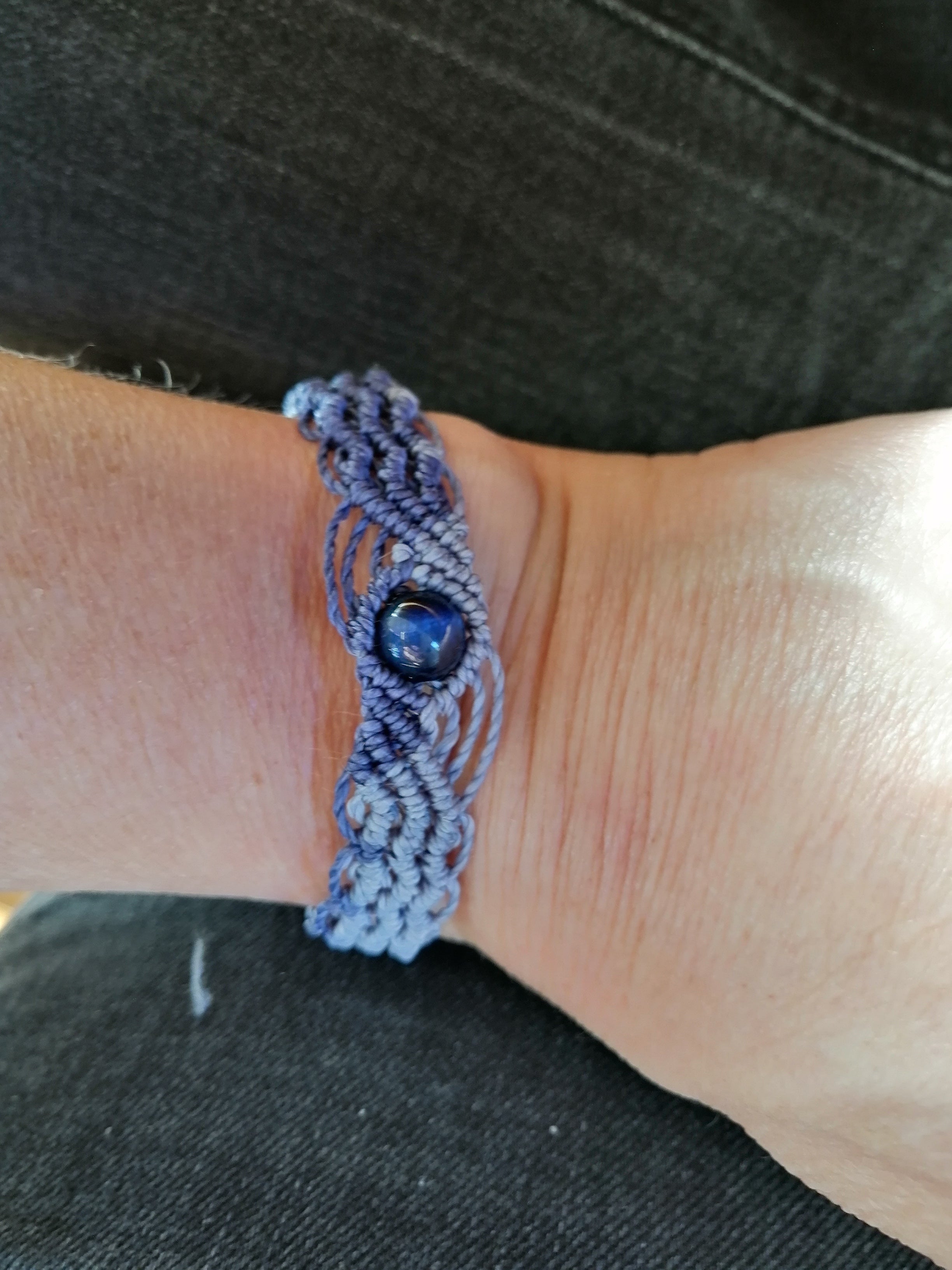 bracelet modèle @solyluna tissé a la main en micro macramé de couleur bleu tendre et bleu marine avec une perle en oeil de tigre bleu.