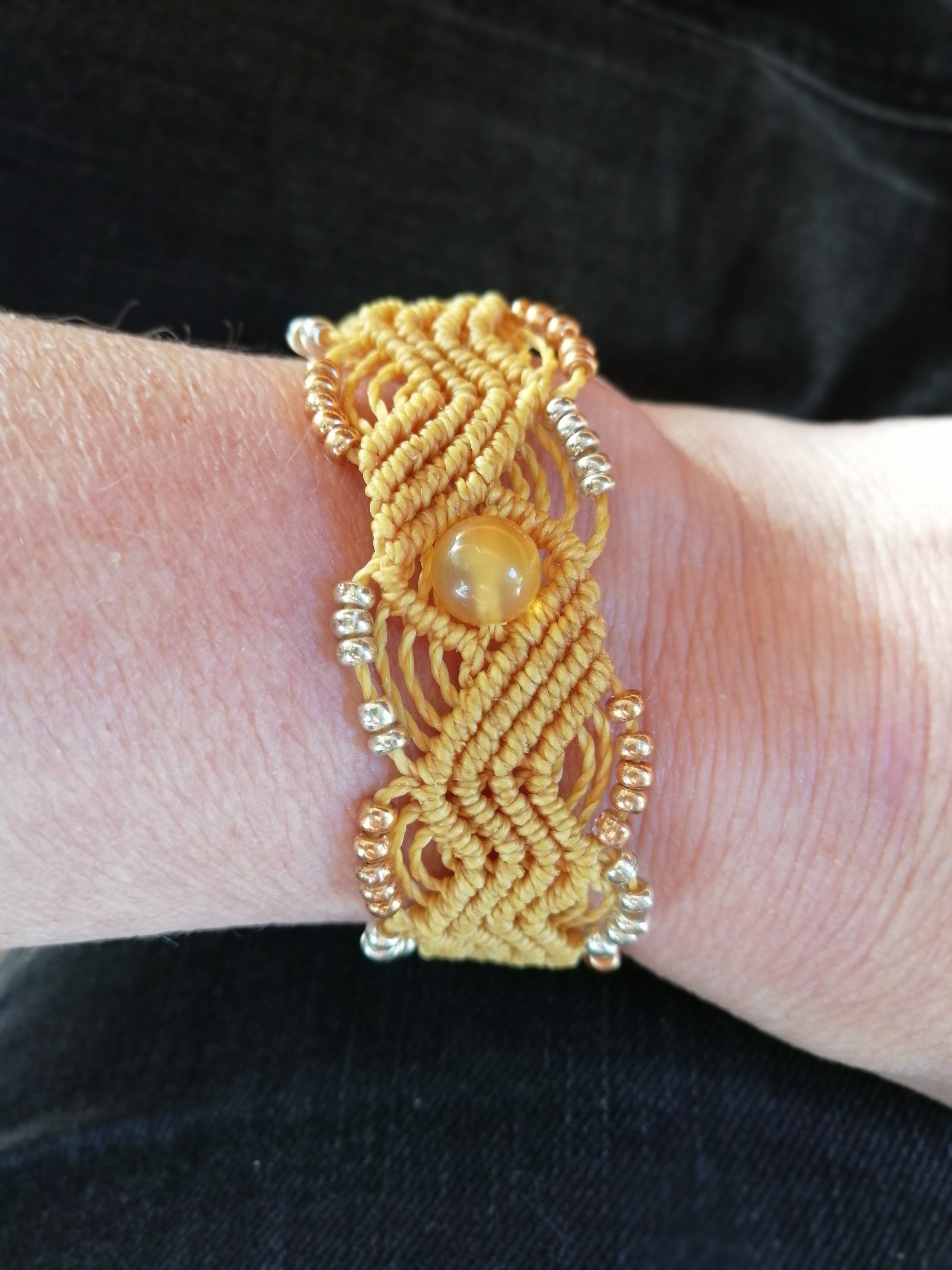 bracelet tissé a la main en micro macramé de couleur motarde  avec un perle en ambre.