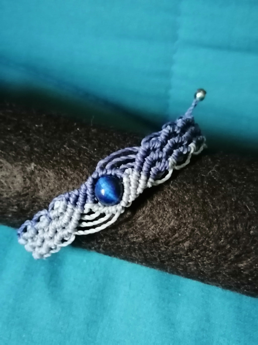 bracelet modèle @solyluna tissé a la main en micro macramé de couleur bleu marine et bleu ciel avec une perle en oeil de tigre bleu.