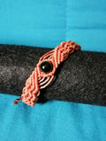 bracelet modèle @solyluna tissé a la main en micro macramé de couleur brique avec une perle en obsidienne.