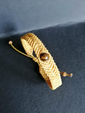 bracelet tissé a la main en micro macramé de couleur moutarde avec une perle en oeil de tigre.