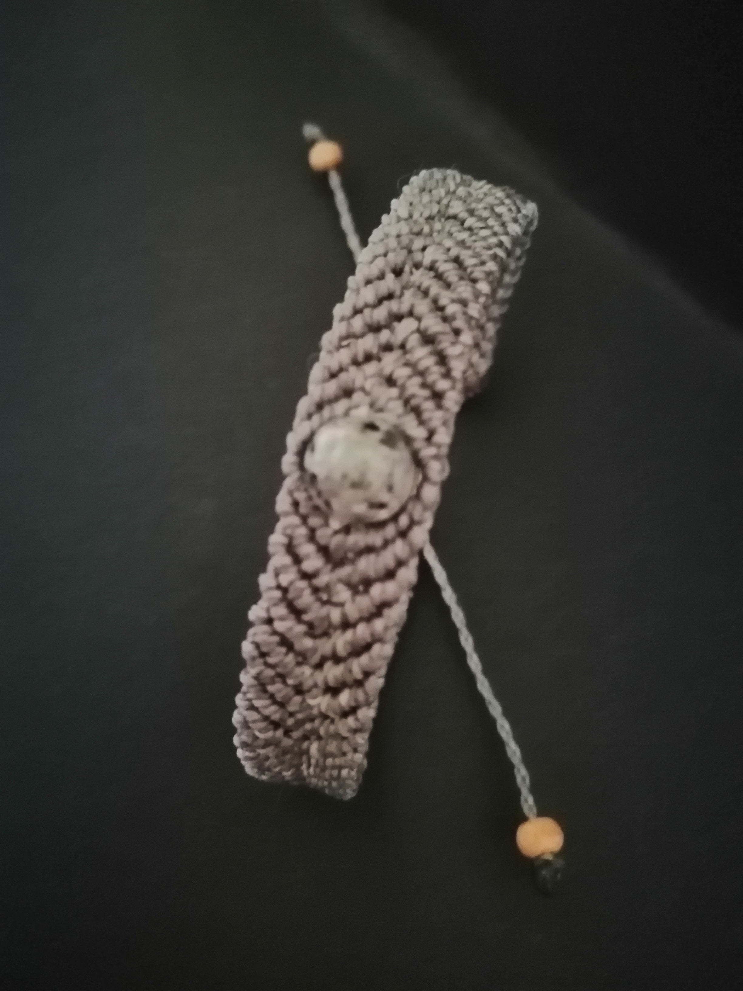 bracelet tissé a la main en micro macramé de couleur gris avec une perle en yooperlite.