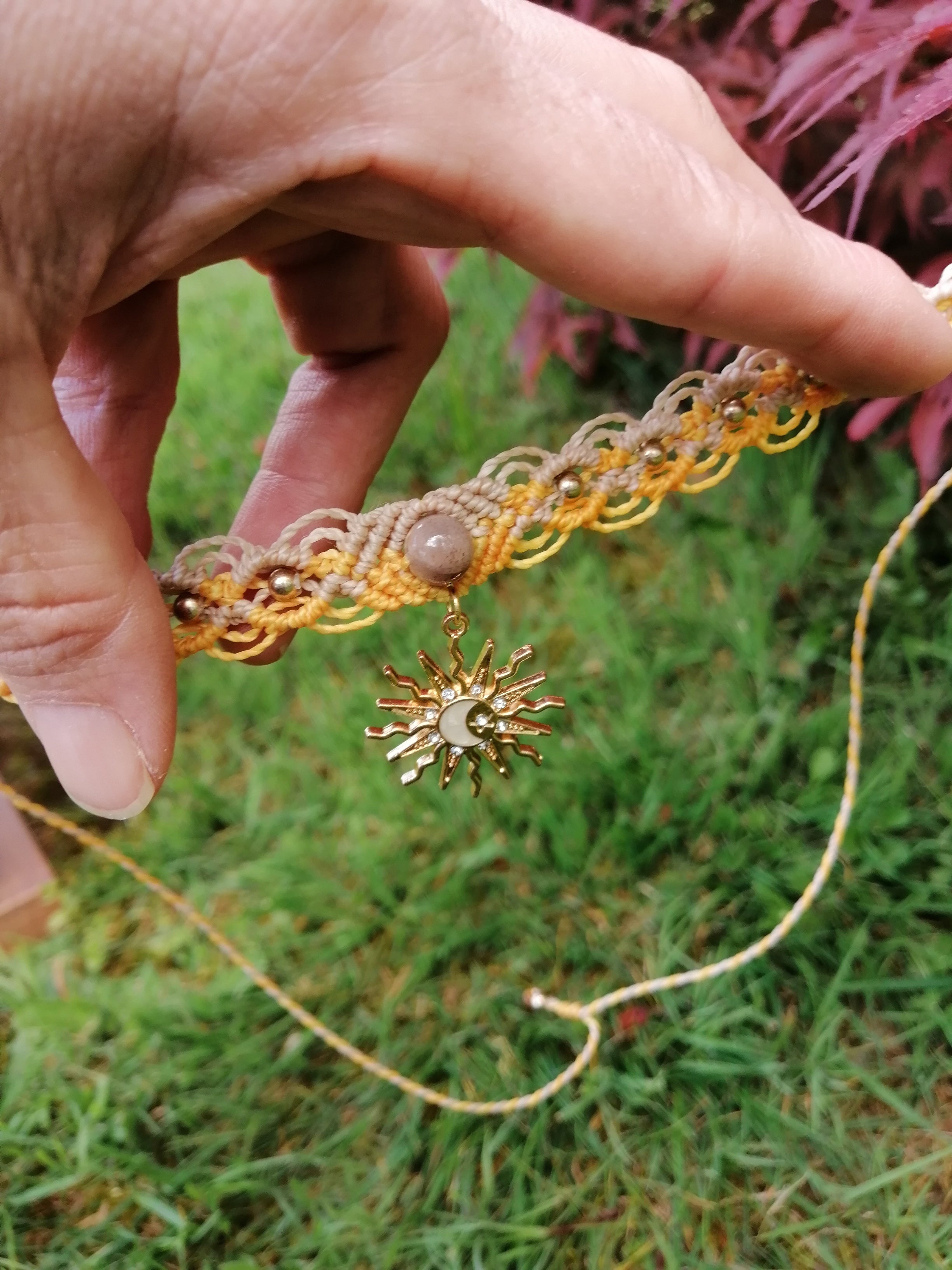 choker tissé à la main en micro macramé de couleur mandarine et sable avec un soleil pendant 