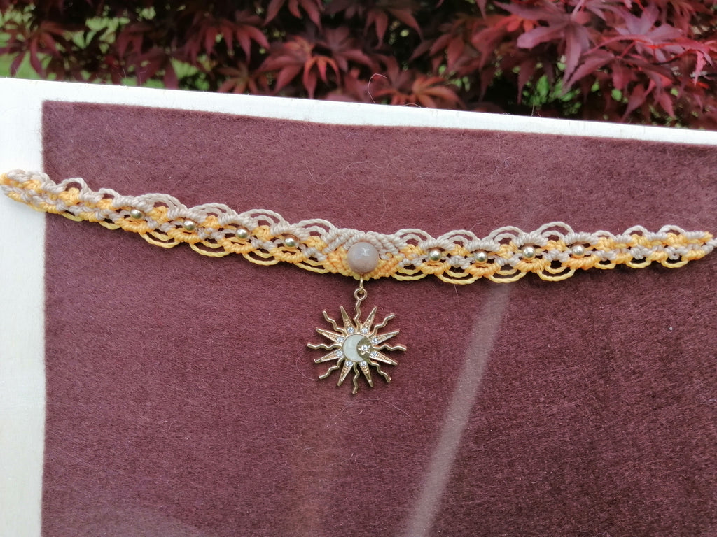 choker tissé à la main en micro macramé de couleur mandarine et sable et un soleil qui pend