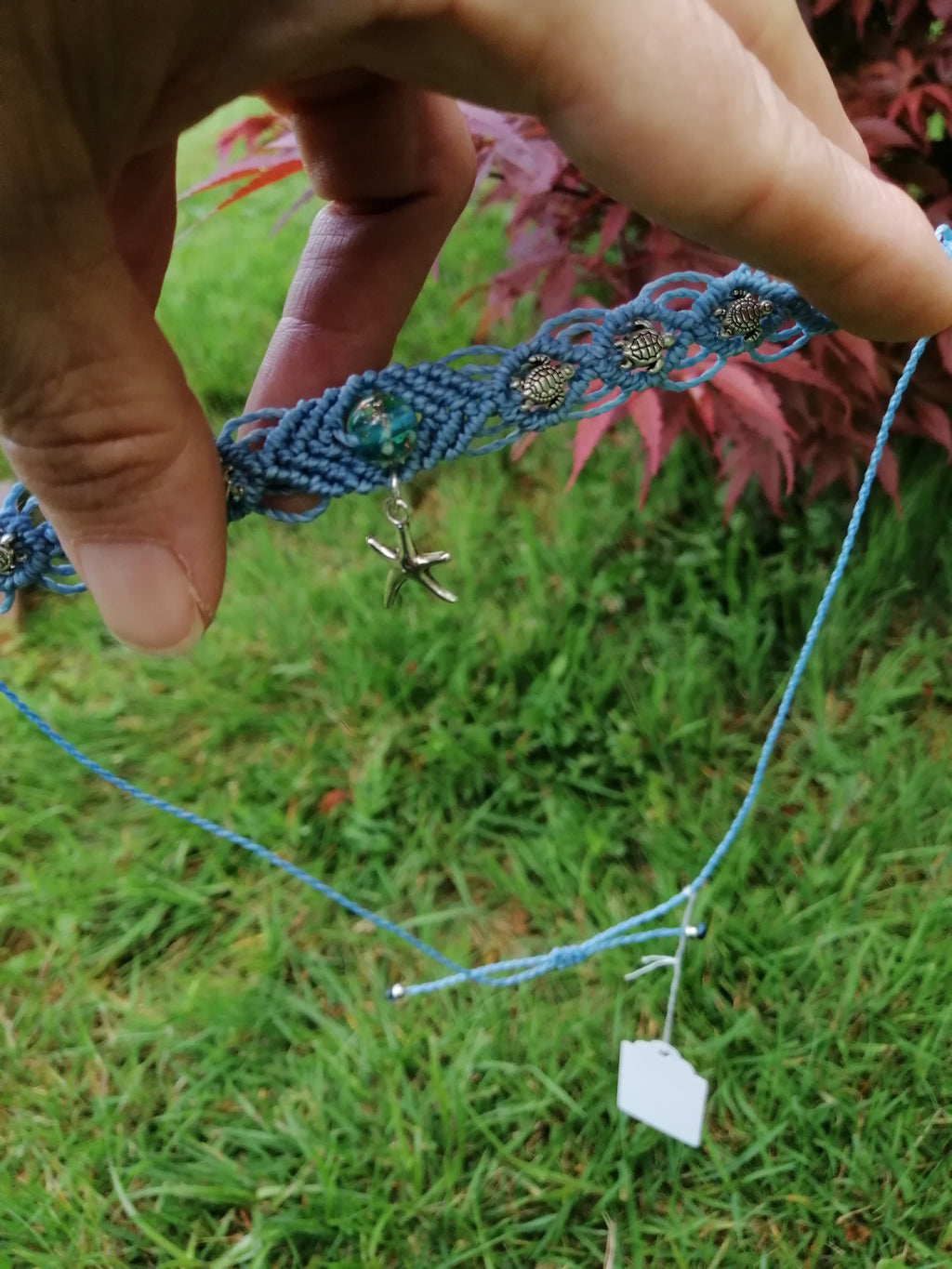 choker tissé à la main en micro macramé de couleur bleu ciel avec 3 tortue de chaque coté et on son centre une perle fluorescente de couleur bleu de 8mm avec une étoile de mer