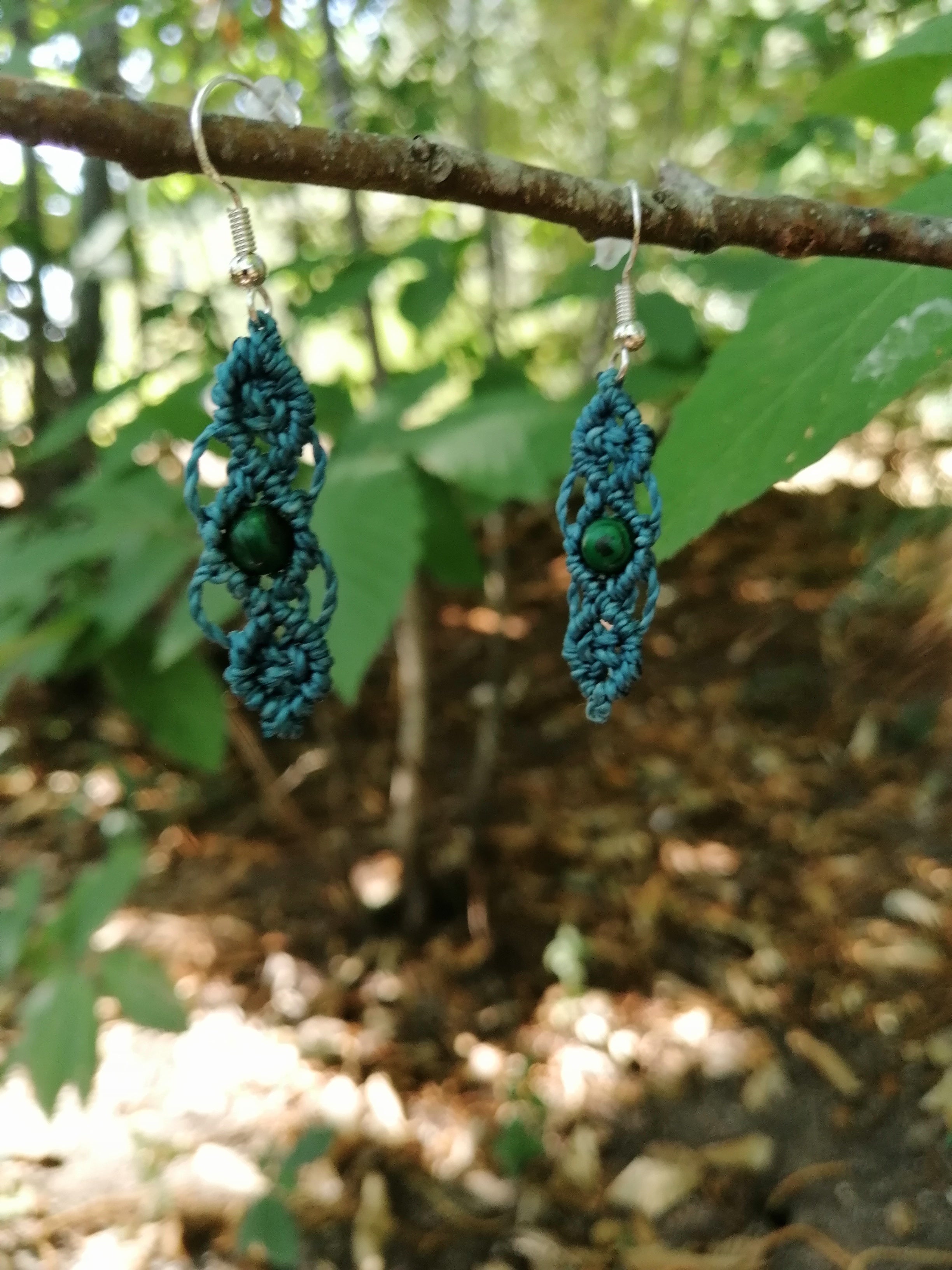 Boucle d'oreille tissé à la main  en micro macramé, de couleur bleu canard, avec une perle verte