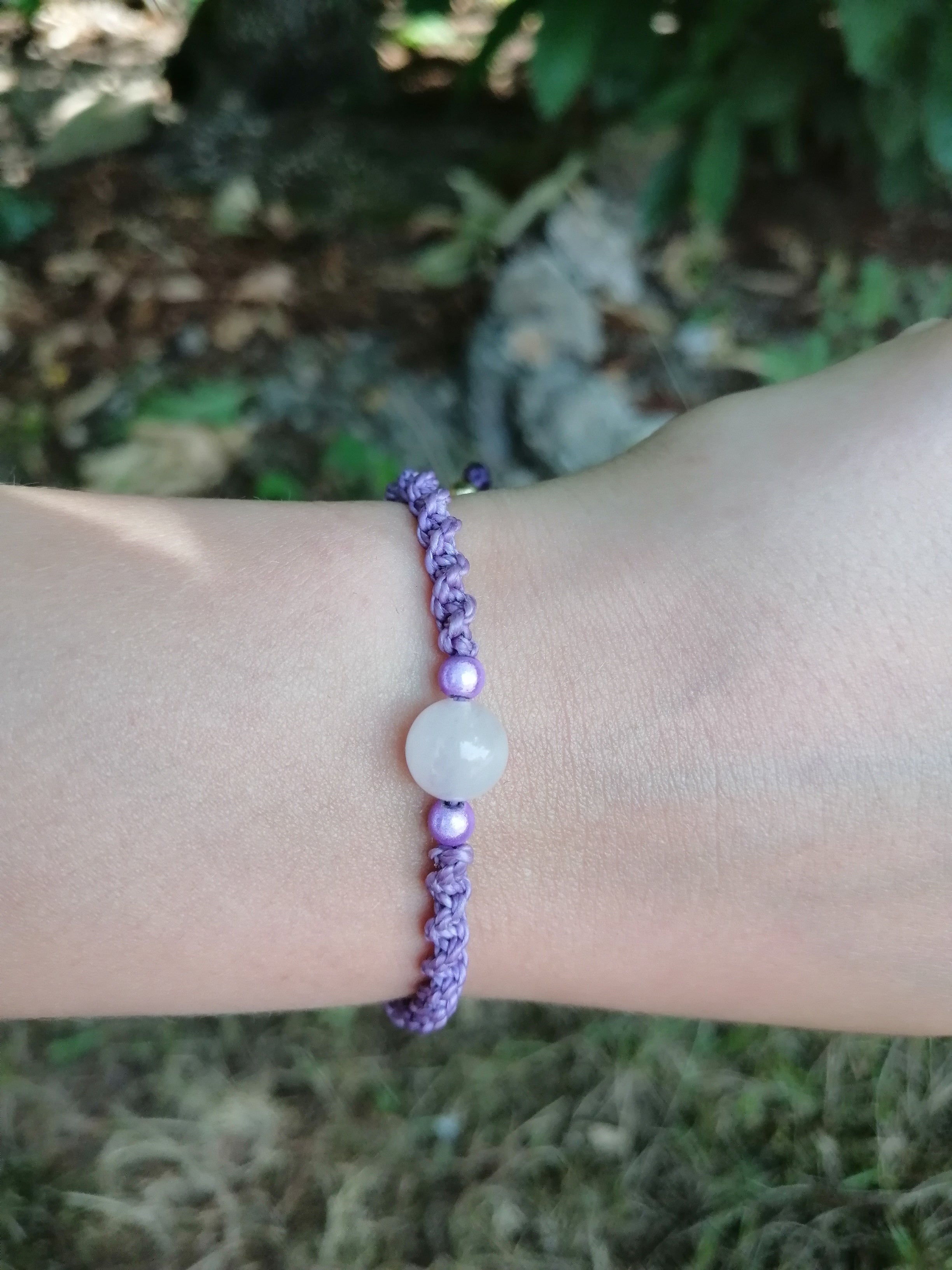 bracelet enfant tissé à la main en micro macramé de couleur mauve avec une perle en  quartz rose et 2 perles réfléchissante de couleur mauve
