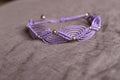 bracelet tissé à la main en micro macramé de couleur mauve avec des perles doré