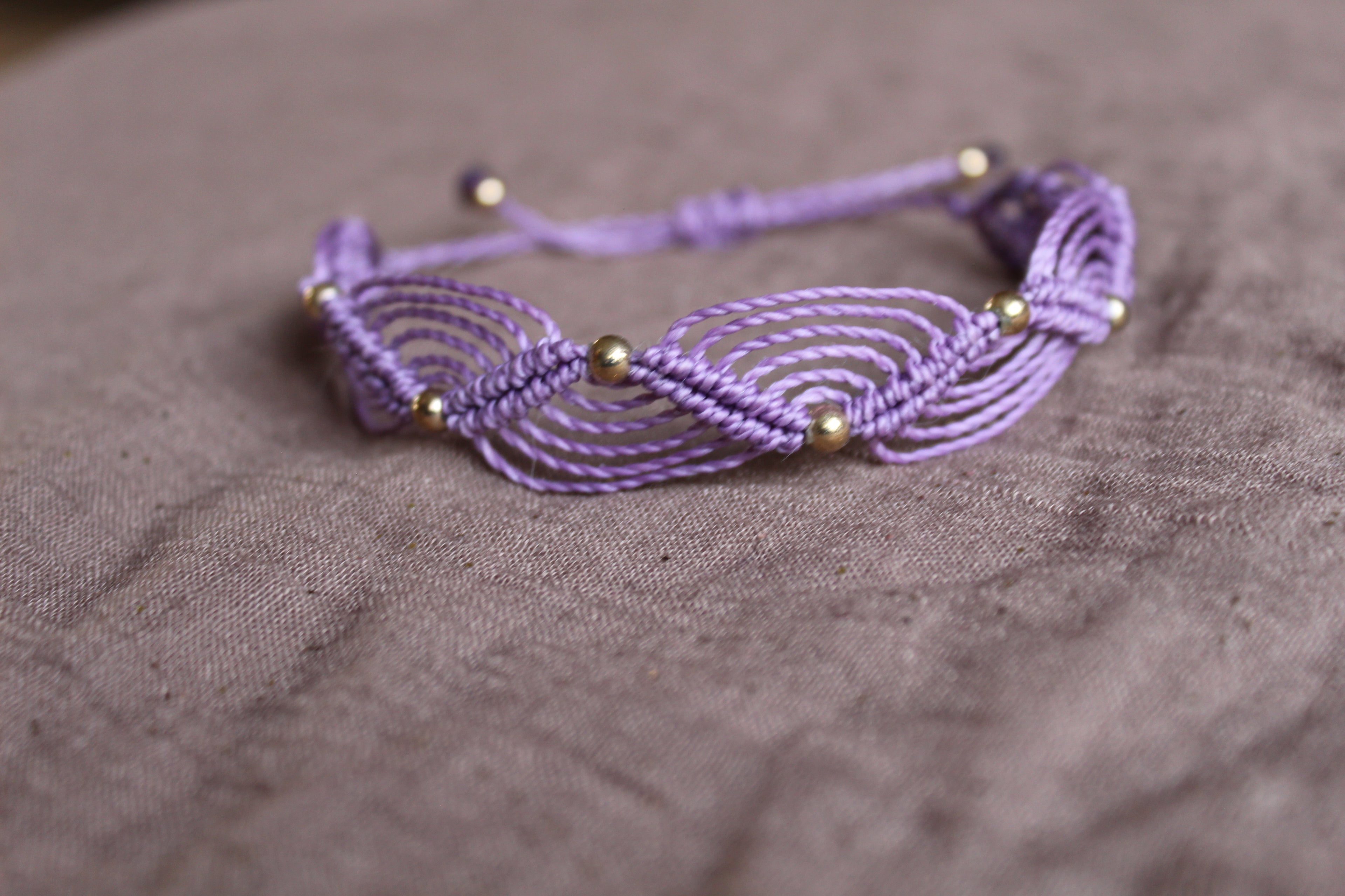 bracelet tissé à la main en micro macramé de couleur mauve avec des perles doré