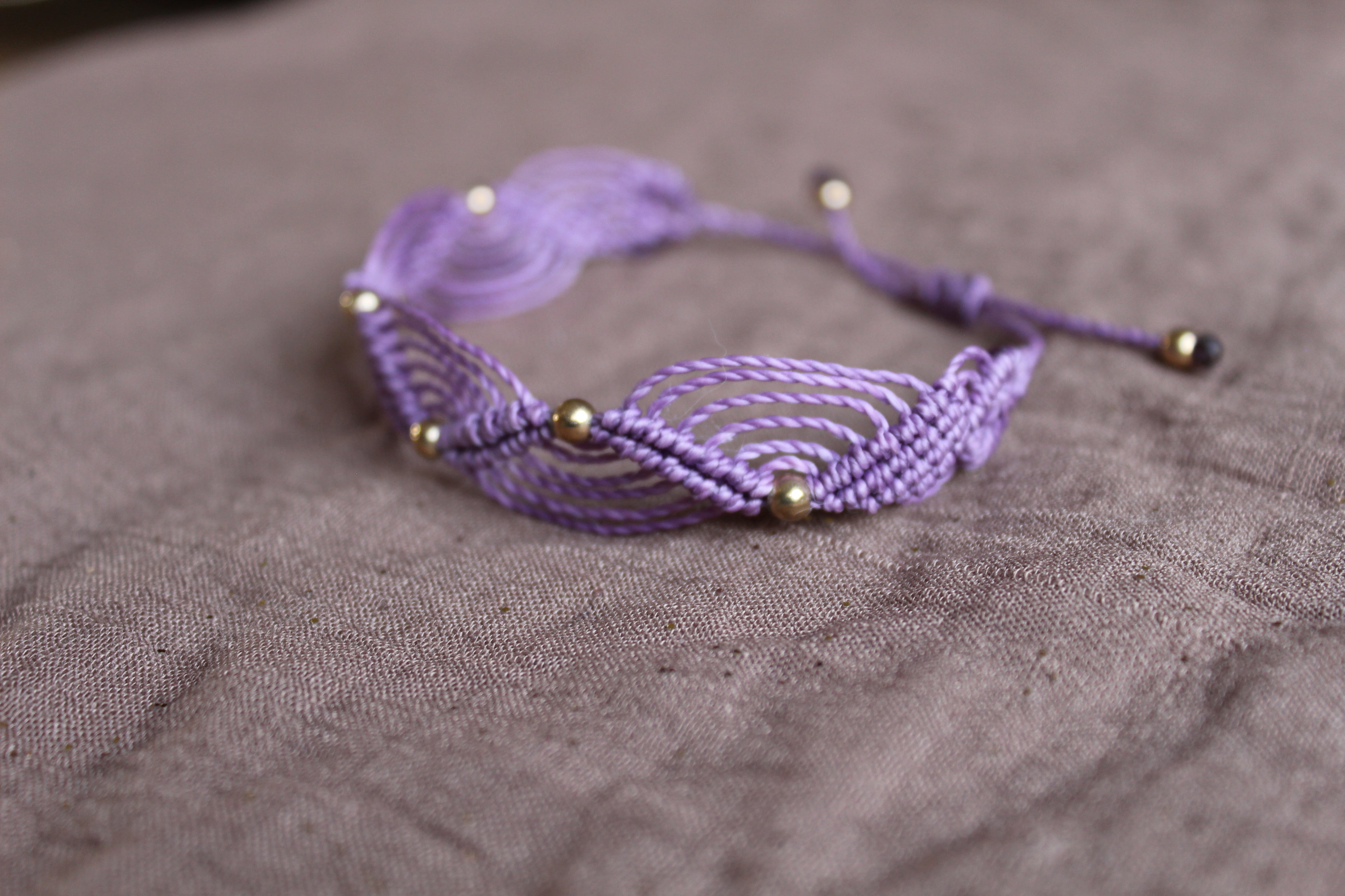 bracelet tissé à la main en micro macramé de couleur mauve avec des perles doré