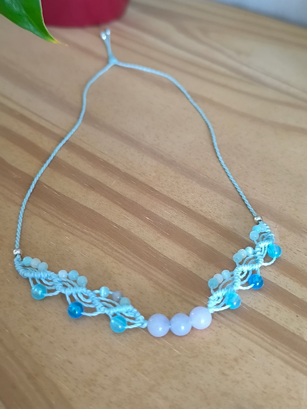ras du cou de couleur azur clair avec des perles en verre, des perles en acrylique fluorescentes et 3 perles en aigue marine. Tissé a la main en micro macramé.