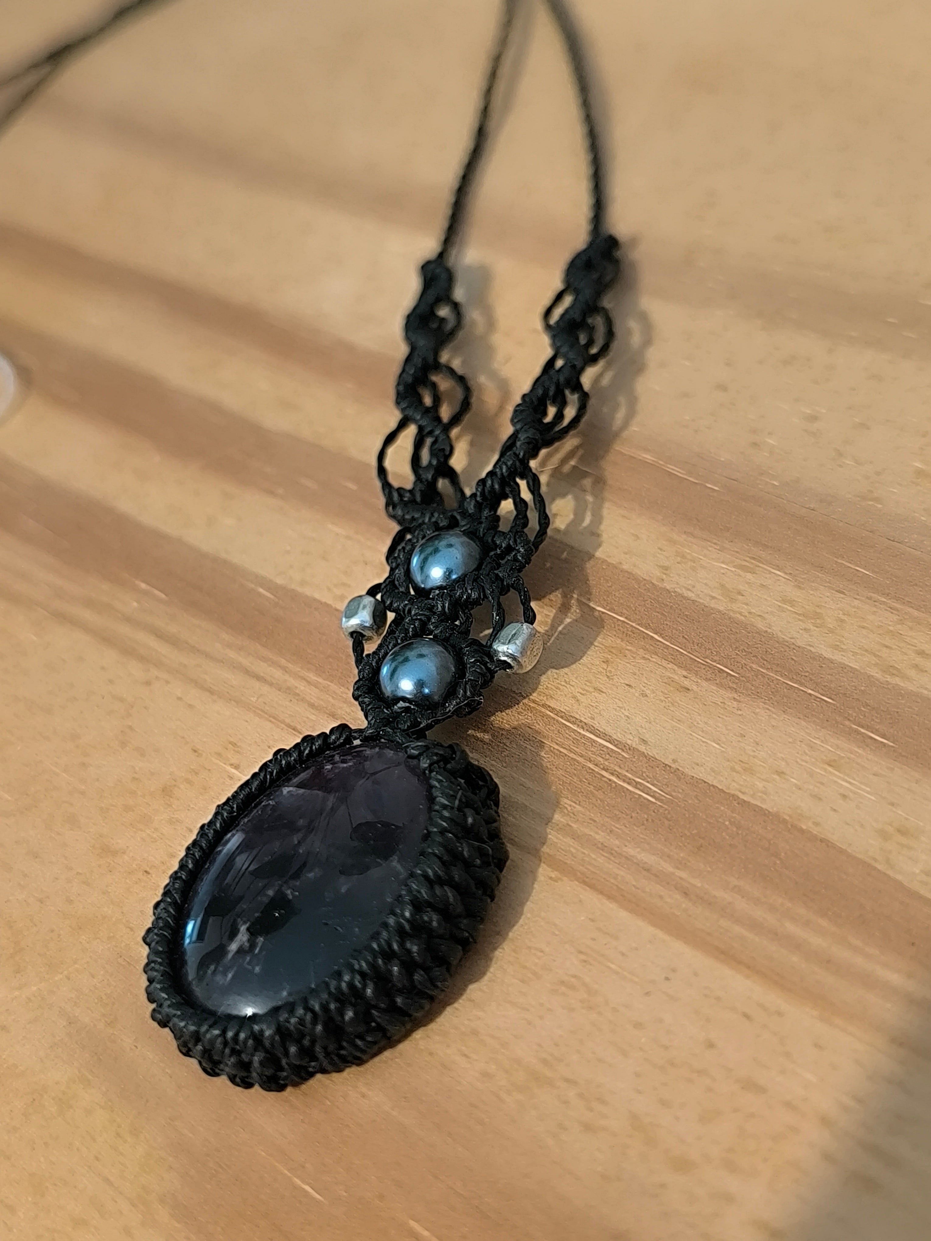 collier tissé a la min en micro macramé avec un cabochon en améthyste et 2 perles en verre et 2 perle en métal.